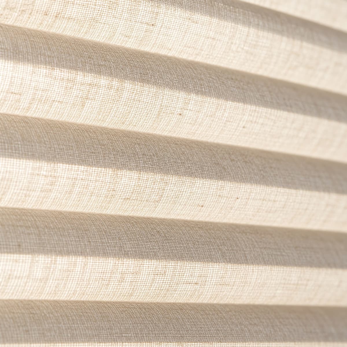 Detail van de vouwen in een plissé stof tegen het licht